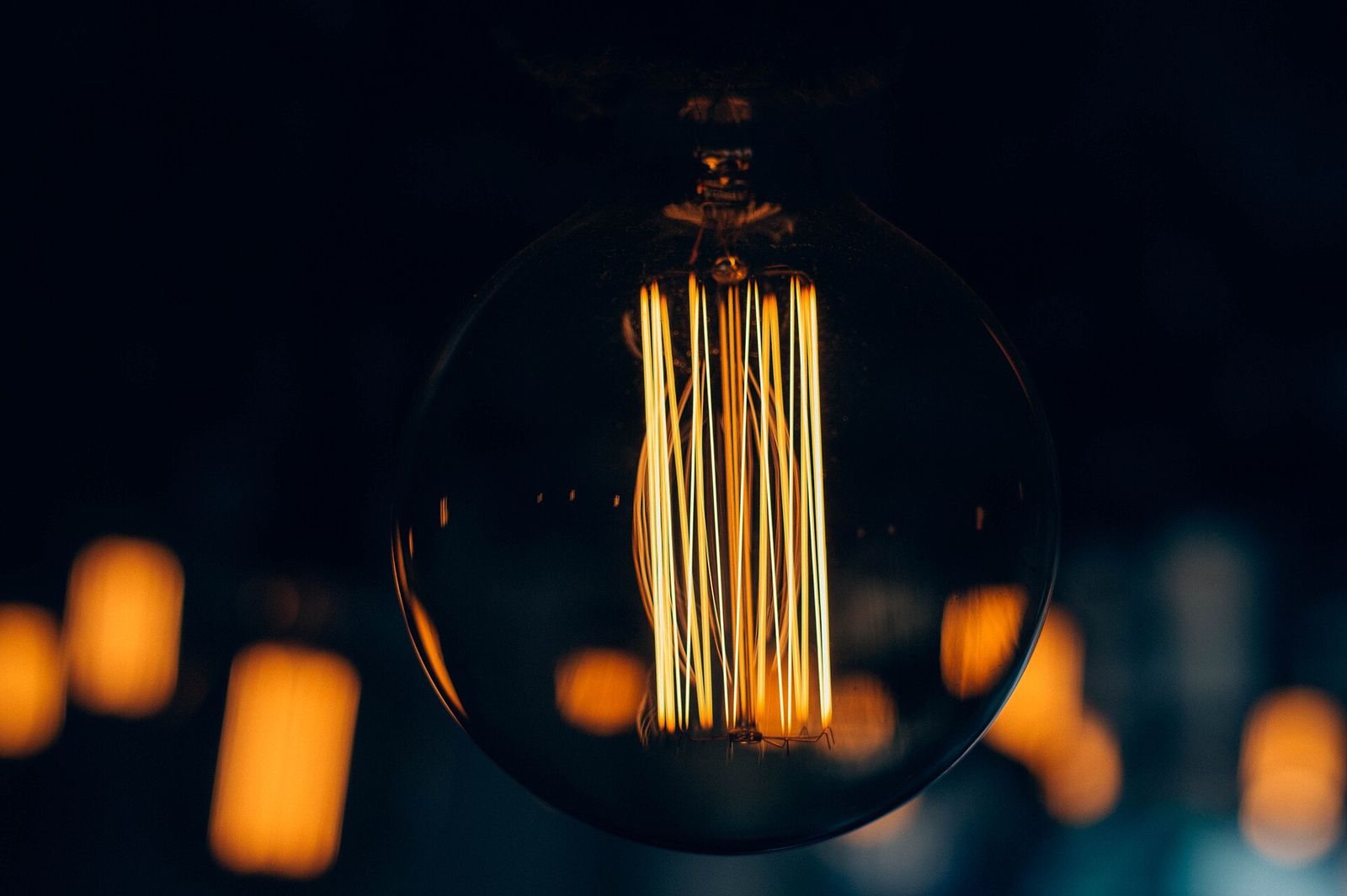A globe filament bulb glowing in the dark